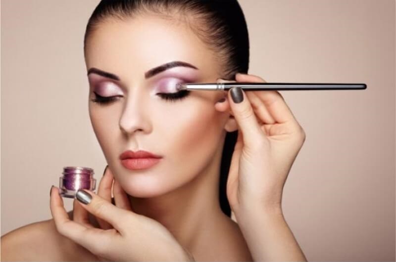 Maquiador feminino profissional aplicando cosméticos no rosto de modelo usa  escova trabalhando no salão de beleza. mulher visagista maquilagem mestre  tingimento de rosto para reforma da aparência do cliente